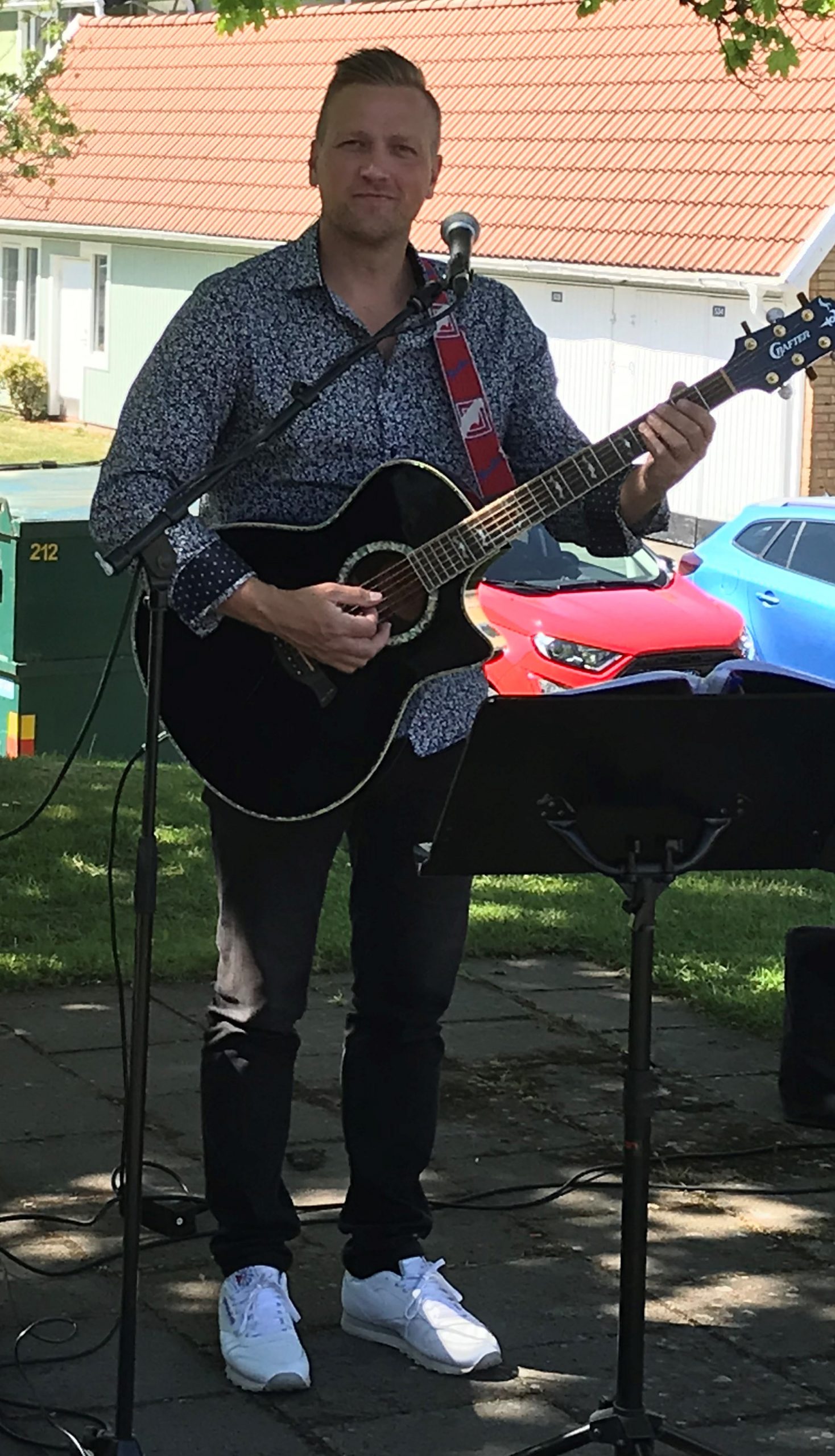 Henrik Strömberg från Scotts med en gitarr i handen på "Musik på bakgård"