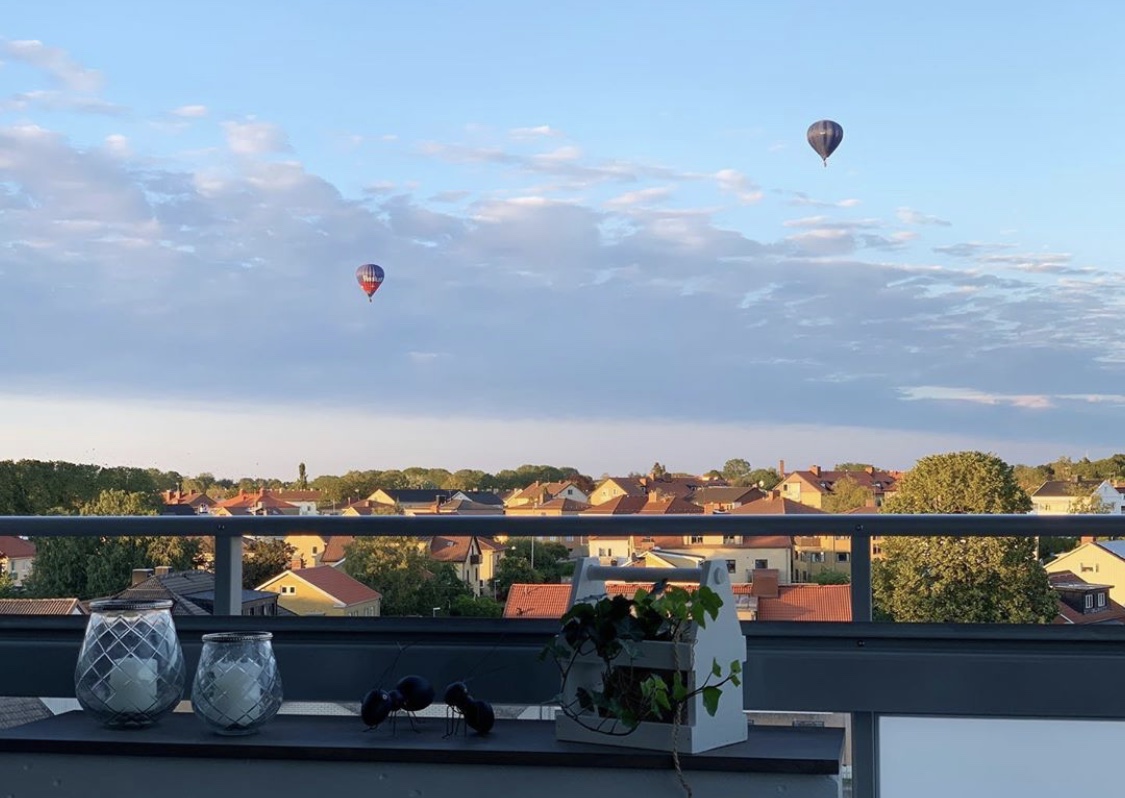 Sommarkväll på balkongen med luftballonger på himlen